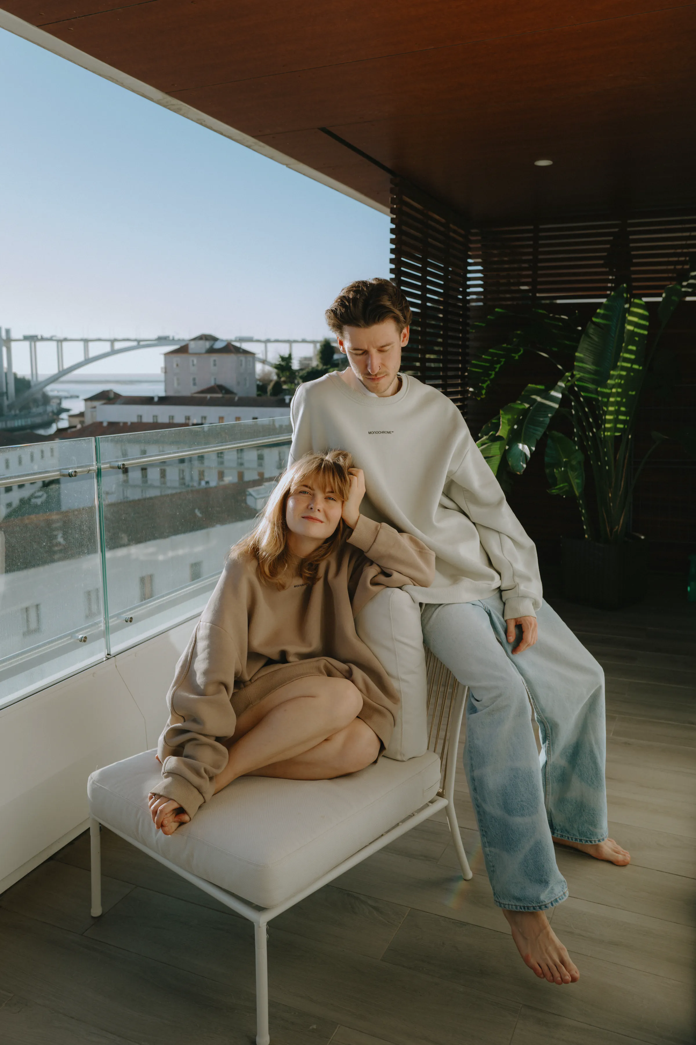 Couple portrait on a balcony lounge with city and waterfront views in soft natural light