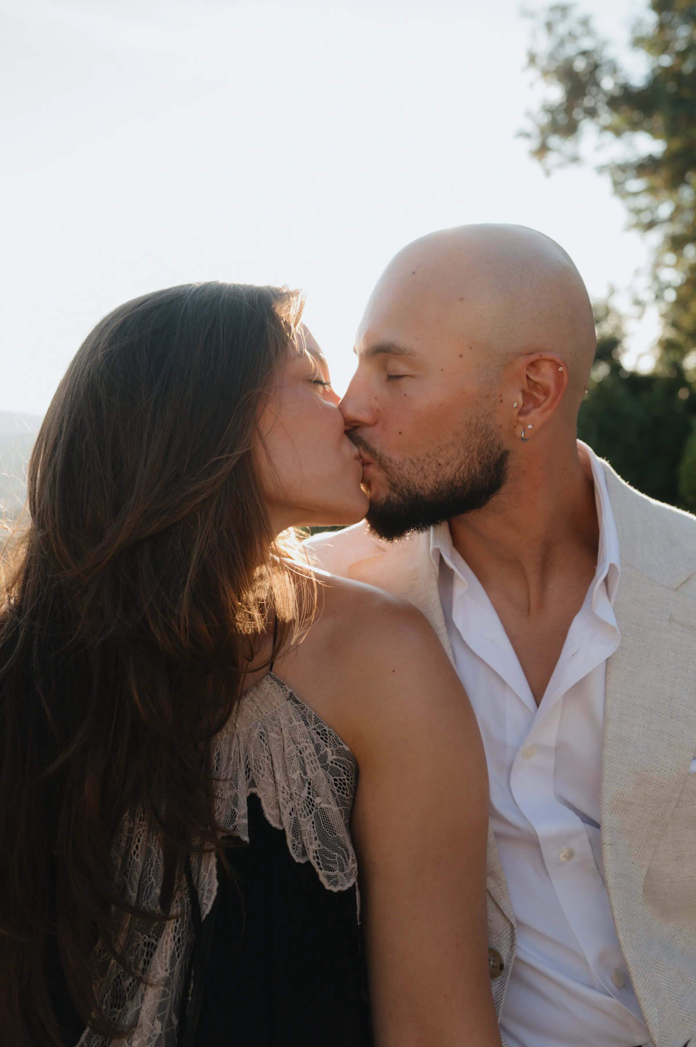 Close portrait of a couple kissing during an outdoor session in soft light.
