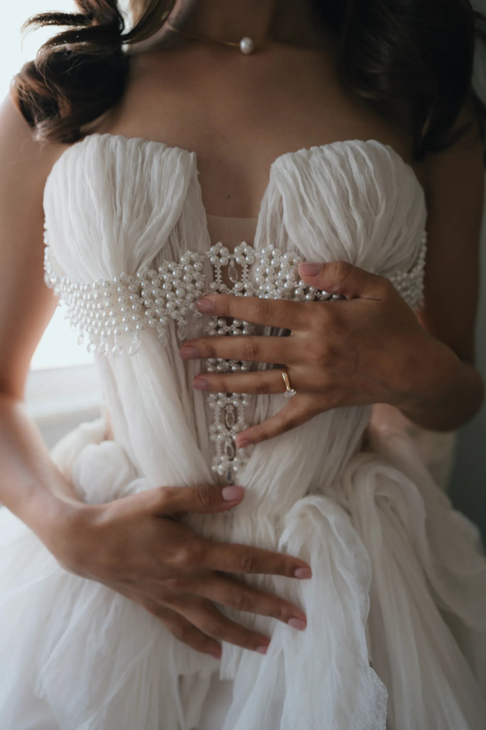 Pearl details on the bride’s wedding dress before the ceremony