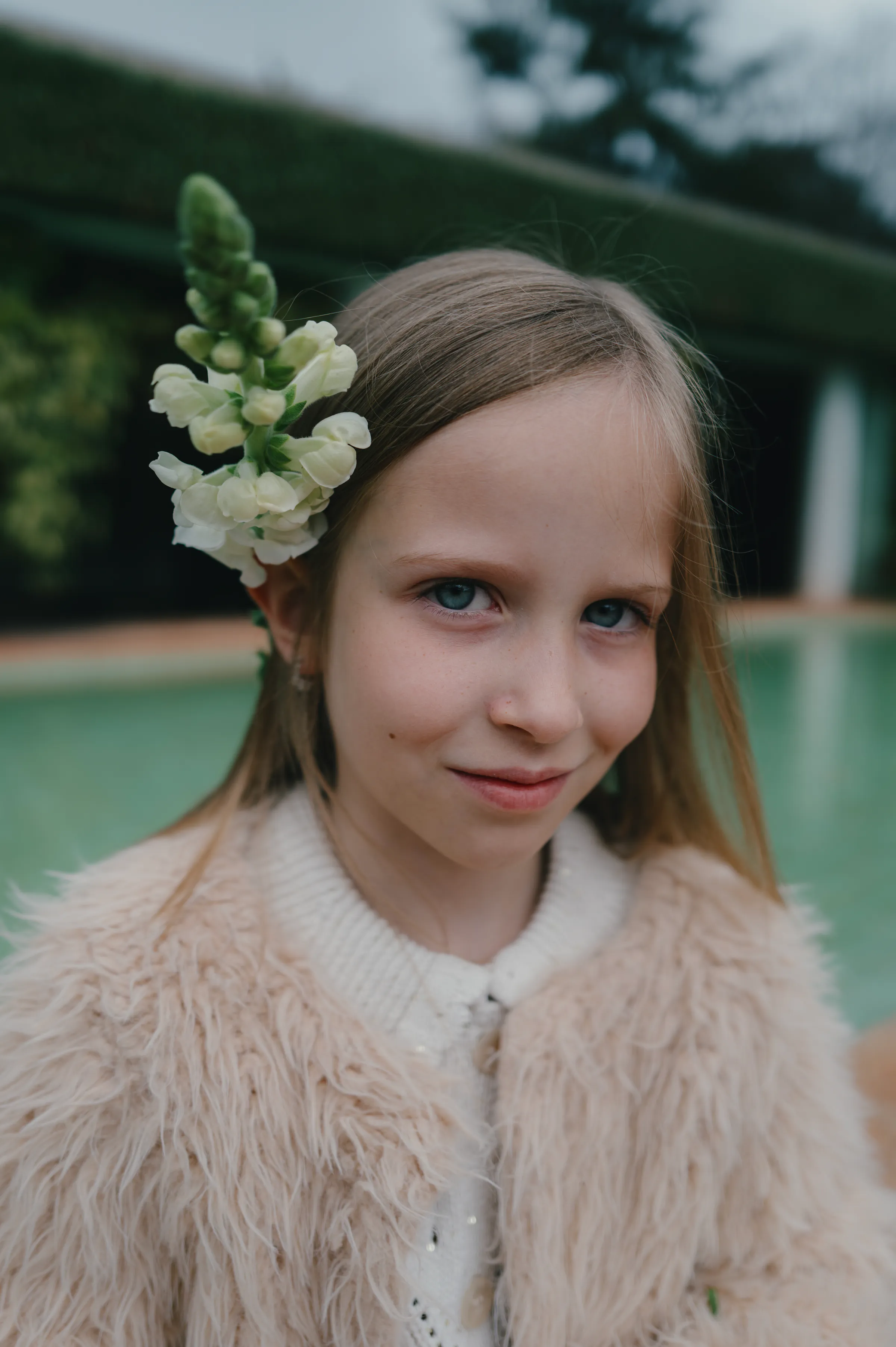 Close portrait of a child with flowers in their hair during a soft light outdoor session.